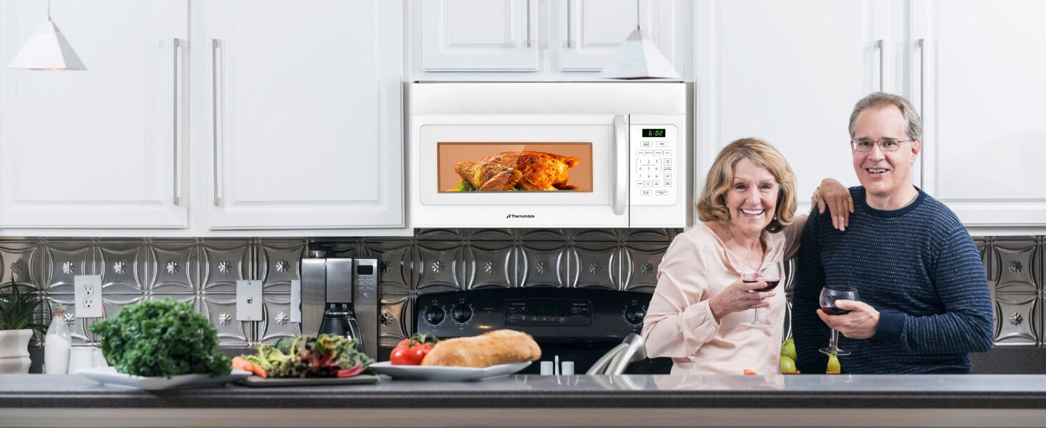 Man and woman standing in a kitchen with a microwave and food on the counter.